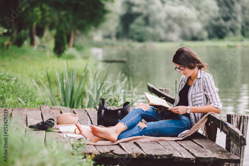 Learning / reading woman concept at summer lake