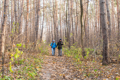 Travel, tourism, hike and people concept - tourists couple in autumn forest