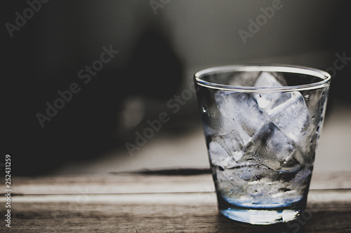 Ice in a glass, placed on a wooden table