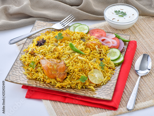 Chicken Biryani, a yummy & fluffy rice dish with spicy savory chicken pieces with salad. photo