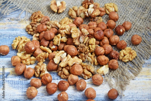 Delicious and healthy nuts on burlap, on a wooden background.