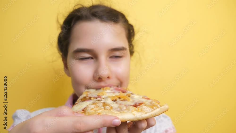happy little girl eating a slice of pizza concept. teenager child hungry eats a slice of pizza. slow motion video. pizza fast lifestyle food concept happy little girl eating a slice of pizza concept. teenager child hungry eats a slice of pizza. slow motion video. pizza fast lifestyle food concept