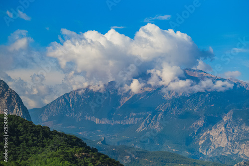 Mountain peaks and amazing cloudy sky. Natural beautiful background. Horizontal color photography.