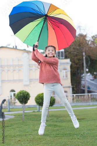 Optimistic child. Colorful accessory for cheerful mood. Girl cheerful child long hair walking park with umbrella. Stay positive and optimistic. Colorful accessory positive influence. Bright umbrella