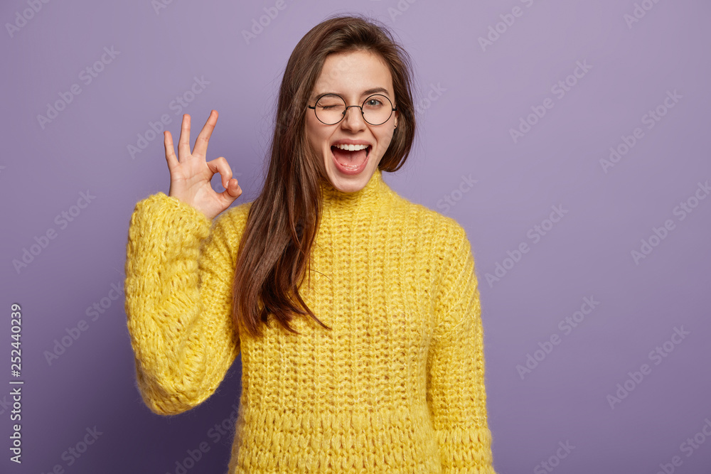 Εκτύπωση καμβά Waist up shot of pleased young woman says good job or well done, makes okay gest