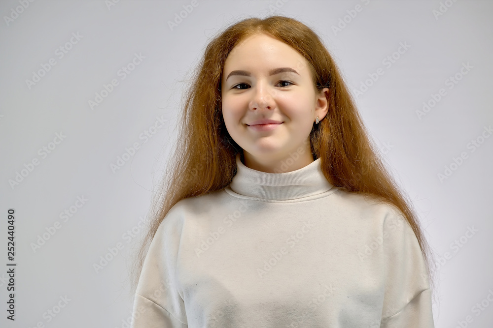 Concept portrait of a cute pretty teenager girl with red hair against gray background smiling and talking. Concept portrait of a cute pretty teenager girl with red hair against gray background smiling and talking.