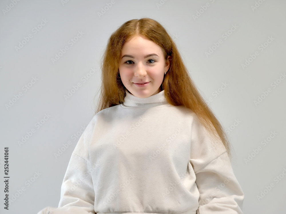 Concept portrait of a cute pretty teenager girl with red hair against gray background smiling and talking. Concept portrait of a cute pretty teenager girl with red hair against gray background smiling and talking.