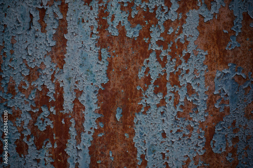 Rusty iron door with cracked blue paint. Painted blue rusty wall shaped texture. Grunge rusty corrosive background painted blue. Steel plate background. Construction industry. Rusty metal background.