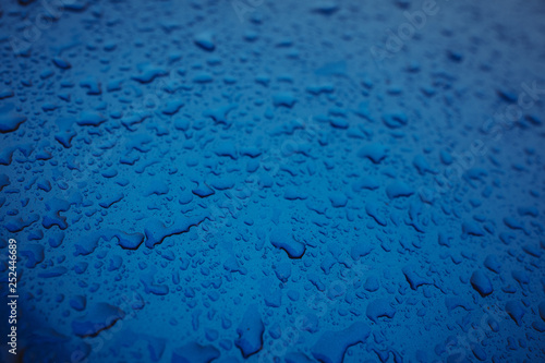 clean water drops on the blue car on the street
