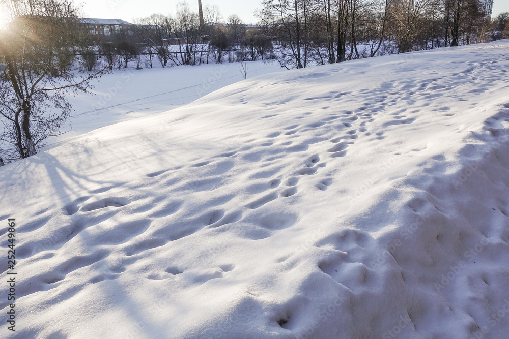 Snow drifts and footprints in the snow. Sunny day. Winter background. Snow drifts and footprints in the snow. Sunny day. Winter background.