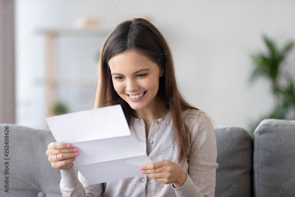 Happy smiling woman reading paper letter, receive good news at home Happy smiling woman reading paper letter, receive good news at home