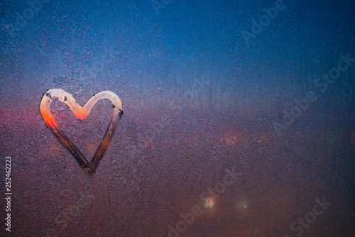 frozen ice heart on the glass of window