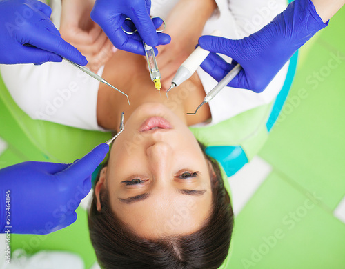 Young female patient visiting dentist office. Woman having teeth examined at dentists