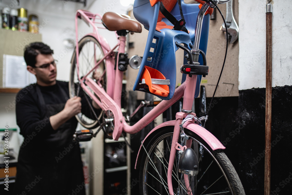 Obraz premium Mechanic repairing a mountain bike in a workshop.