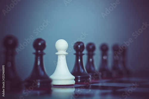 Group of black pawns in one line and one white pawn. Business team concept, different people