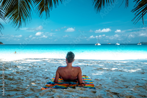 young men in swim short on tropical beach of Praslin Seychelles photo