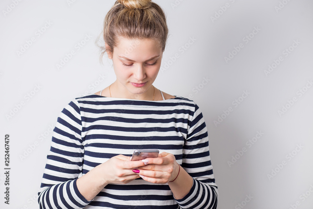 Portrait of a smiling casual woman typing or reading text message on mobile smart phone Portrait of a smiling casual woman typing or reading text message on mobile smart phone
