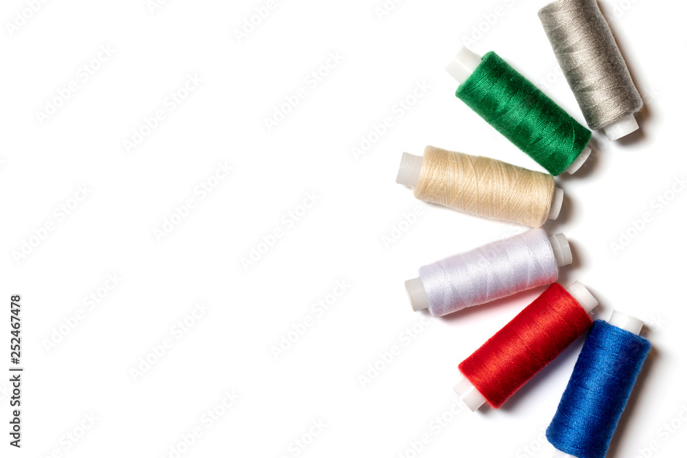 Colored thread coils on white background, sewing, handmade and DIY concept - layout for hobby and DIY such as dressmaking ebroidery and needlework with copy space Colored thread coils on white background, sewing, handmade and DIY concept - layout for hobby and DIY such as dressmaking ebroidery and needlework with copy space