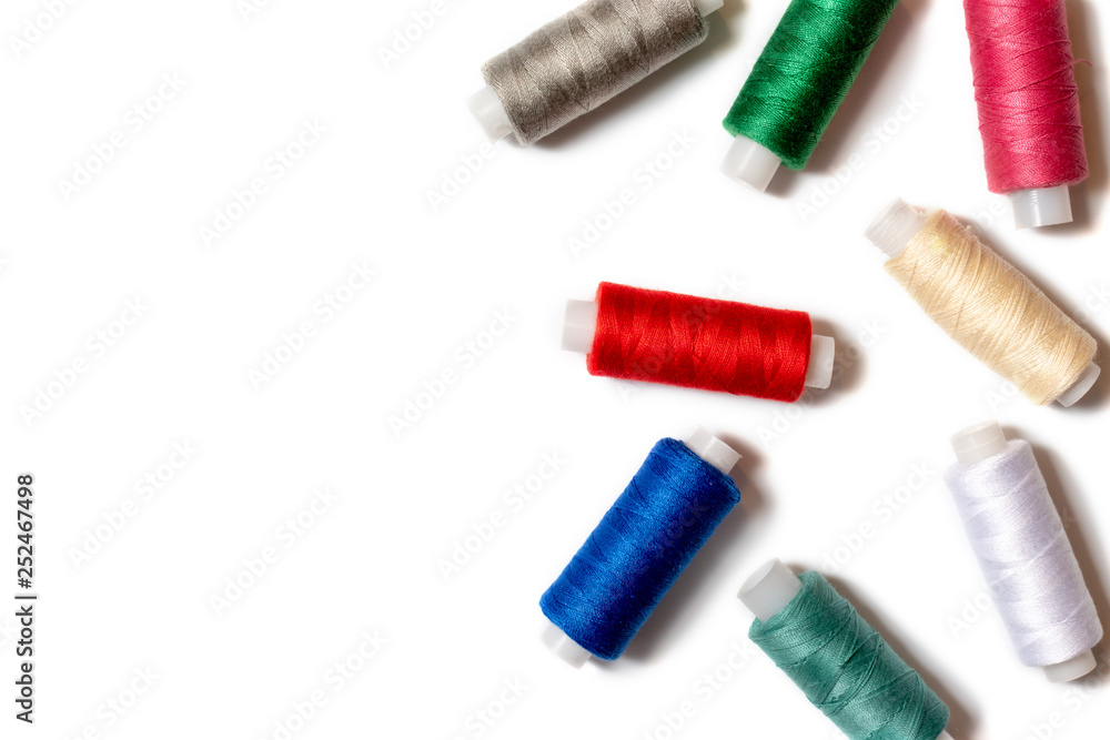 Colored thread coils on white background, sewing, handmade and DIY concept - design for seamstress and tailor with copy space Colored thread coils on white background, sewing, handmade and DIY concept - design for seamstress and tailor with copy space