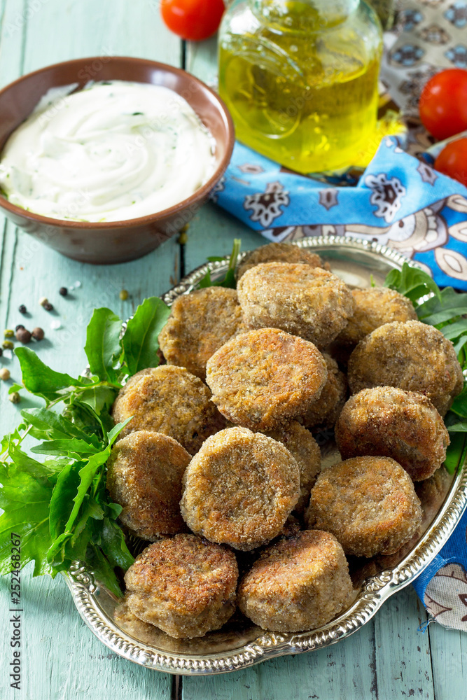 Middle eastern or arabic dishes. Fresh vegetarian falafel. Mung falafel with garlic yogurt sauce on wooden table. Middle eastern or arabic dishes. Fresh vegetarian falafel. Mung falafel with garlic yogurt sauce on wooden table.