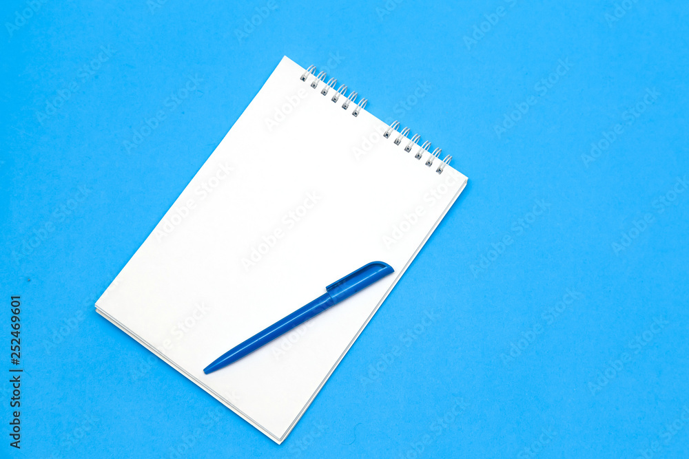 White notepad and blue pen on blue background. speech bubble White notepad and blue pen on blue background. speech bubble