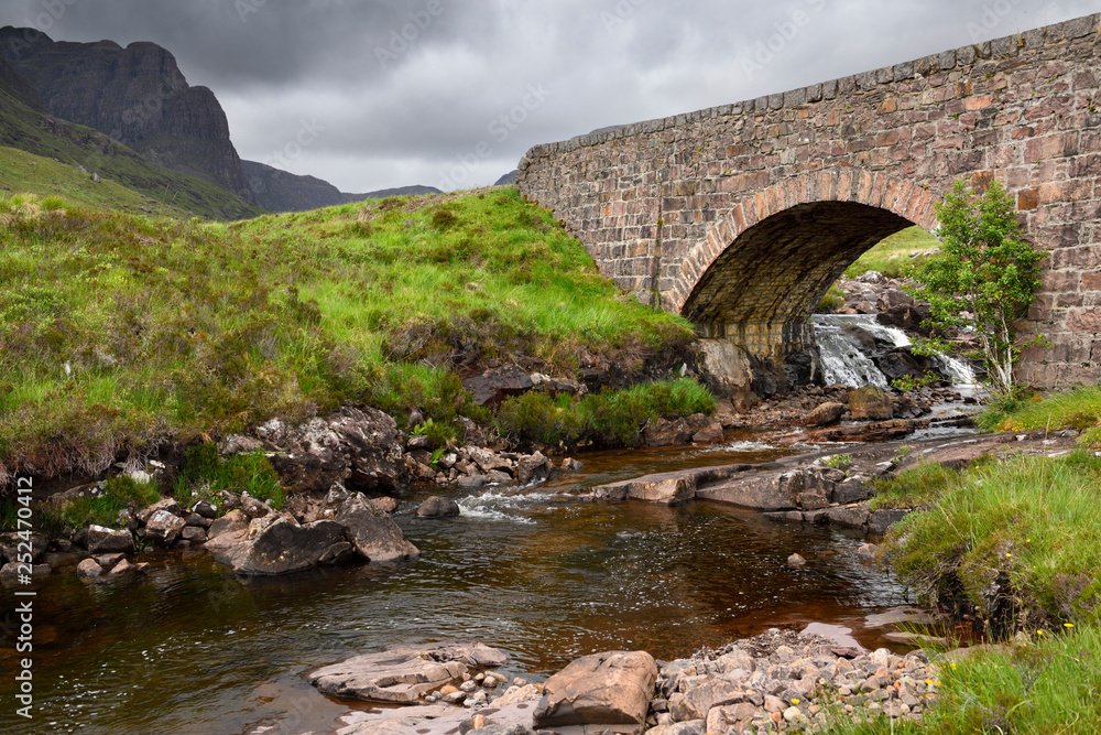Red stone bridge over Russel Burn river of Bealach na Ba road mountain pass on Applecross Peninsula Scottish Highlands Scotland UK