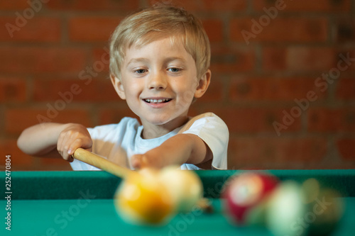 5-6 years old boy playing billiard