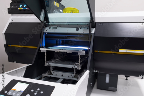 large UV printer prints layers of paint on a sheet of paper and bakes by ultraviolet in the printing house