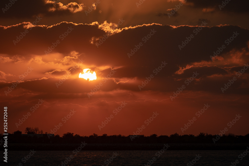 Fototapeta premium Dramaitc sunset and sunrays peaking through clouds