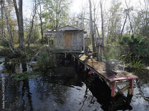 Obraz na plátne small wooden cottage with a dingy and abandoned boat in the swamps of New Orlean