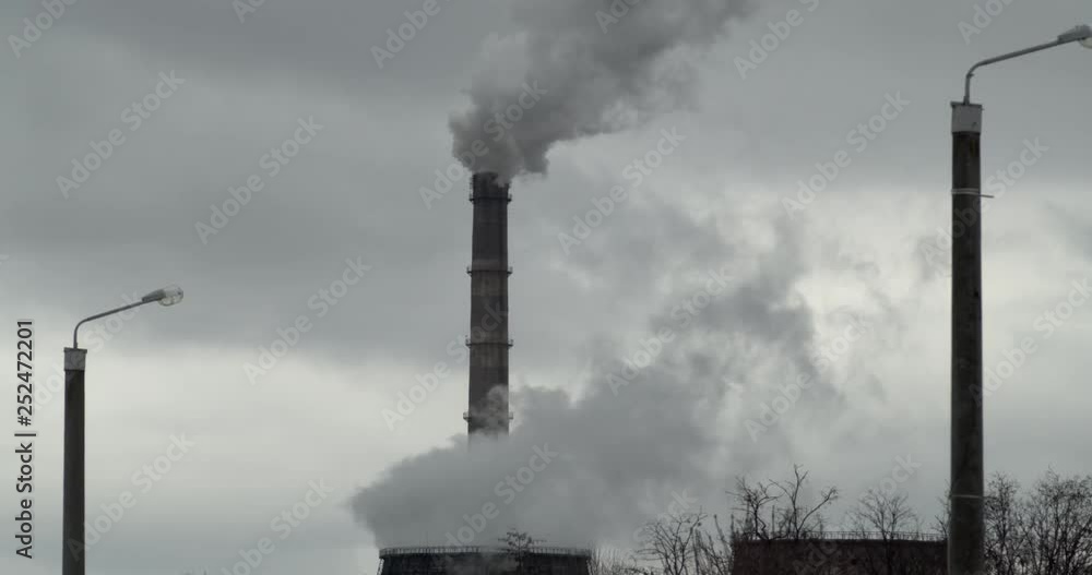 Pollution by an old coal-fired power plant. From the chimney there is acrid gray smoke. Close-up. Slow motion. 4K. Pollution by an old coal-fired power plant. From the chimney there is acrid gray smoke. Close-up. Slow motion. 4K.