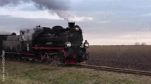 Old passangers train running on the tracks. Retro locomotive with steam engine loopable footage.