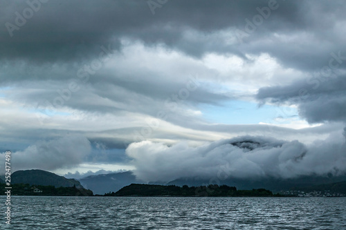 sea and landscape with steep mountains and dramatic cloud sky in the fords of middle Norway, Scandinavia