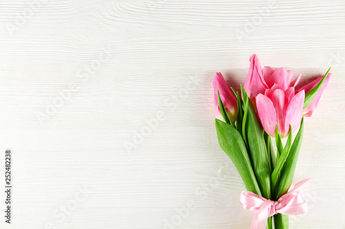 Fototapeta Naklejka Na Ścianę i Meble -  Fresh flower composition, bouquet of bi color pink tulips, white wooden texture table background. International Women's day, mother's day greeting concept. Copy space, close up, top view, flat lay.