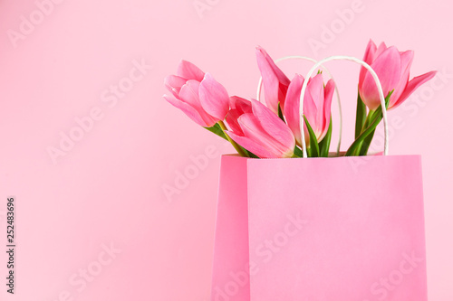 Fototapeta Naklejka Na Ścianę i Meble -  Beautiful bouquet of tender pink tulips in blank paper shopping bag. International Women's day, mother's day greeting concept. Copy space, close up, top view, flat lay.