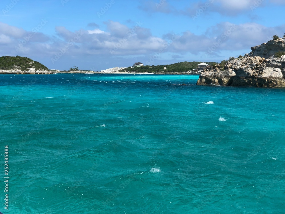 Turquoise waters of the Bahamas with rocky islands in the background