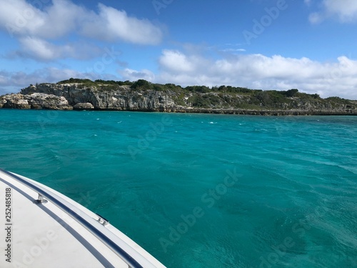 Wide view of the Thunderball grotto, a popular filming location in the Exuma Cays, with the side of a boat in the picture.
