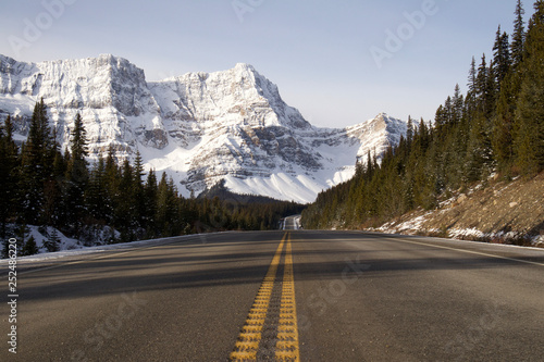 Lonely road with snowy mountains in the background