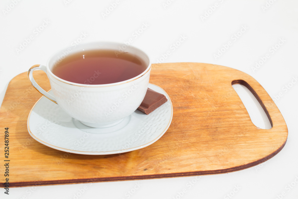 Obraz premium A mug of tea with lemon and chocolate.