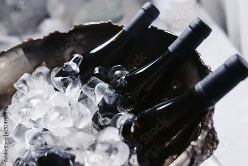 Photography Closeup and selective focus of wine and champagne bottles chilling in a bucket full of ice