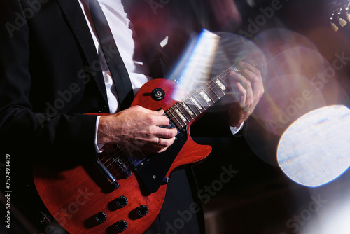 Man playing guitar on a musical concert or in a studio. Close-up view. Dynamic shot in motion slow shutter speed and flash, long exposure