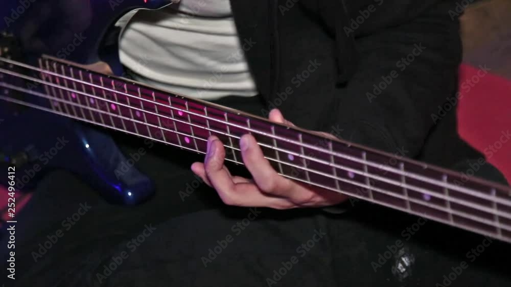 Man bass guitarist play on electrical bass guitar on concert. Fingerboard close-up. Man bass guitarist play on electrical bass guitar on concert. Fingerboard close-up.