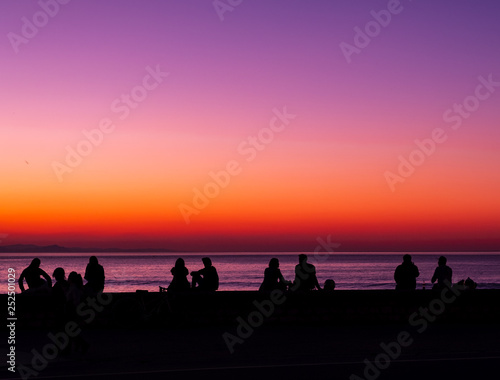 SAN SEBASTIAN  SPAIN - March 02  2019  People in backlight at the sea at sunset  city of San Sebastian