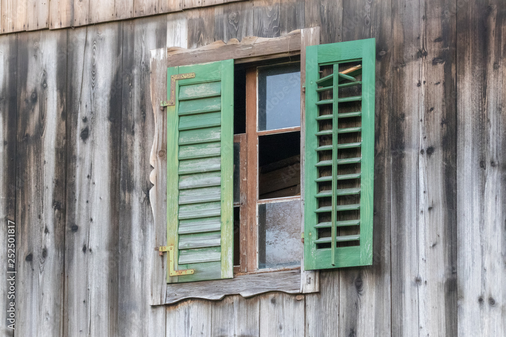 kaputtes Fenster mit grünen Fensterläden