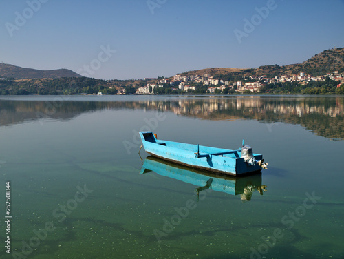 Boat in lake Orestiada, in Kastoria Greece. Reflections on lake water. © Kostas