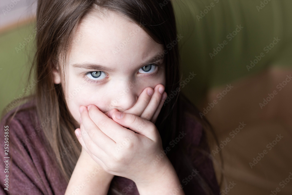 Frightened child covers his mouth with his hands. Frightened child covers his mouth with his hands.