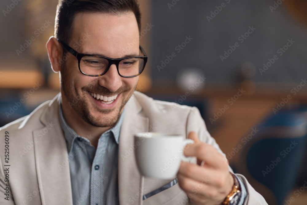 Happy mid adult businessman drinking coffee while relaxing in a cafe Happy mid adult businessman drinking coffee while relaxing in a cafe