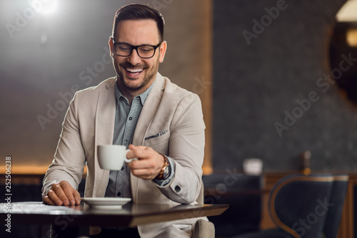 Happy mid adult businessman drinking coffee while relaxing in a cafe