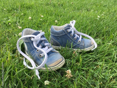 pair of baby shoes on green grass © 1L26