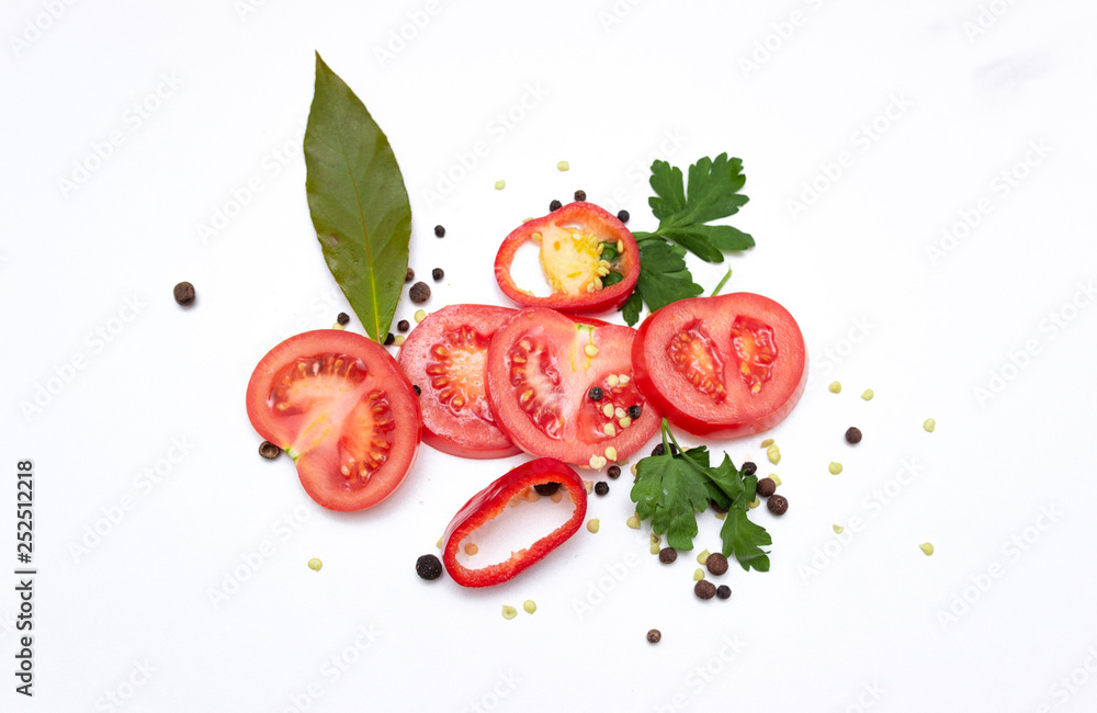 Fototapeta Sliced fresh tomatoes, bell peppers, seasonings and greens, isolated on white background. top view.